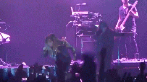 A Man Playing A Guitar And Another Man Playing A Keyboard Are On A Stage GIF