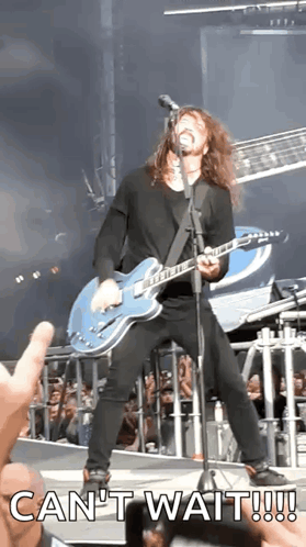 A Man Playing A Guitar And Singing Into A Microphone With The Words Can 'T Wait GIF