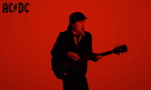 A Man Playing A Guitar In Front Of A Red Background With Ac Dc Written On It GIF