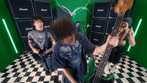 A Man Playing A Guitar In Front Of A Wall Of Marshall Amplifier Stacks GIF