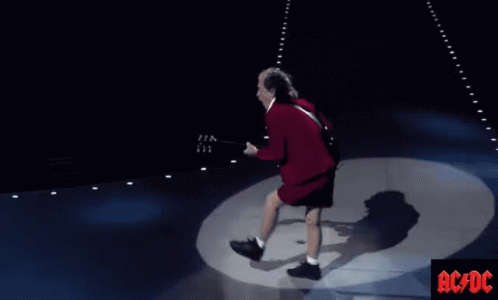 A Man Playing A Guitar On A Stage With Ac/dc Written On The Bottom Right GIF