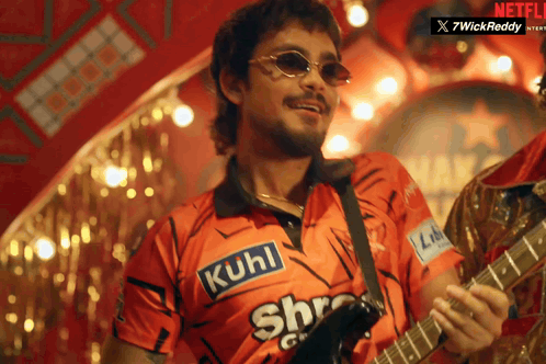 A Man Playing A Guitar With A Shirt That Says Kuhl On It GIF