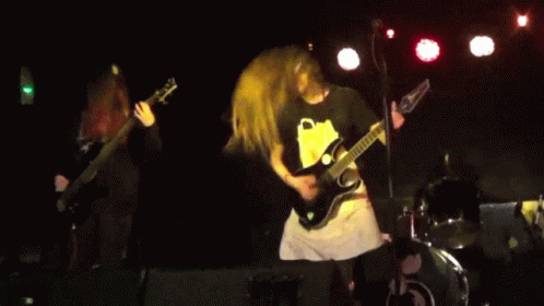 A Man Playing A Guitar With The Letter C On The Front GIF
