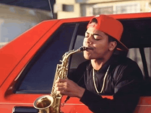 A Man Playing A Saxophone In A Red Car GIF