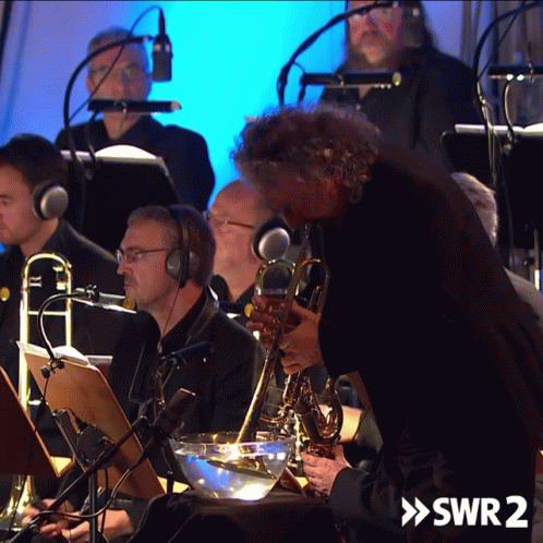 A Man Playing A Saxophone In An Orchestra With The Words Swr2 On The Bottom Right GIF