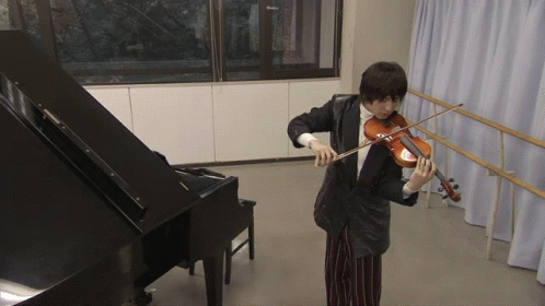 A Man Playing A Violin In A Room With A Piano GIF