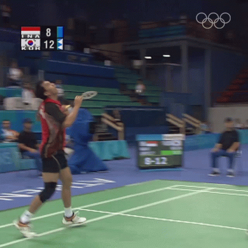 A Man Playing Badminton With A Scoreboard That Says 8 And 12 GIF