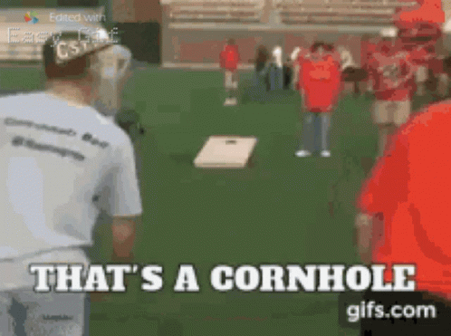 A Man Playing Cornhole With The Words That 'S A Cornhole Behind Him GIF