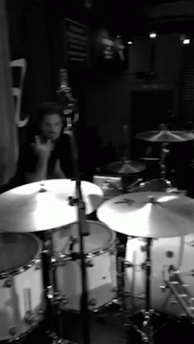 A Man Playing Drums In A Black And White Photo With The Number 7 In The Background GIF