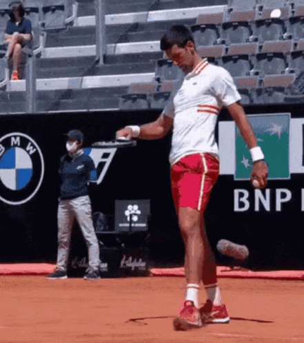 a man playing tennis on a court with a bnp logo in the background