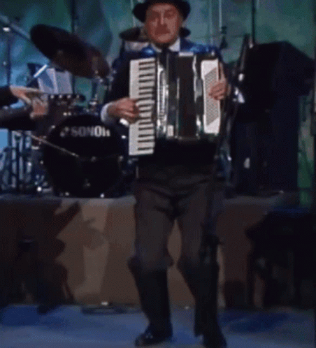 A Man Plays An Accordion In Front Of A Sonor Drum GIF