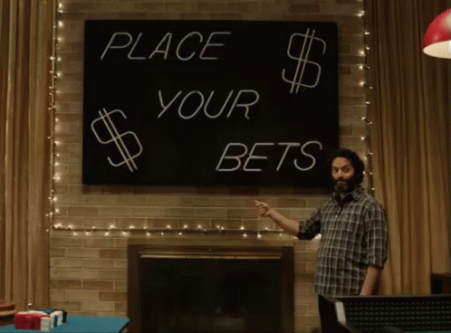a man pointing at a sign that says place your bets