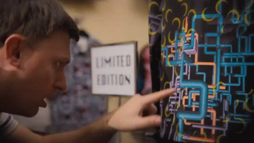 A Man Points At A Limited Edition Sign On A Wall GIF