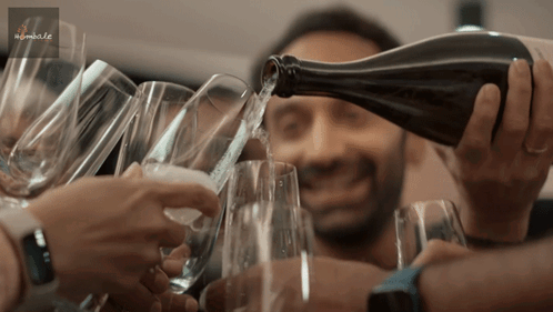 A Man Pouring A Bottle Of Wine Into A Glass GIF