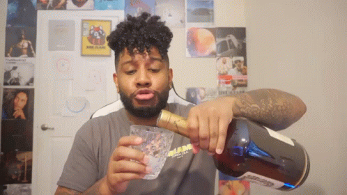 A Man Pouring A Drink From A Bottle With A Label That Says ' Glenlivet ' GIF
