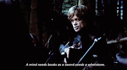A Man Reading A Book With The Words " A Mind Needs Books As A Sword Needs A Whetstone " Next To Him GIF