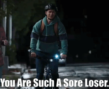 A Man Riding A Bike With The Words " You Are Such A Sore Loser " Above Him GIF