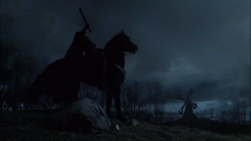 A Man Riding A Black Horse In A Field GIF