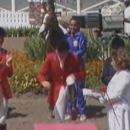 A Man Riding A Horse Is Being Congratulated By A Woman GIF