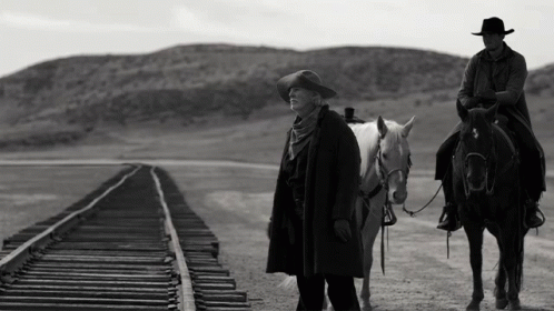 A Man Riding A Horse Next To A Woman On A Train Track GIF