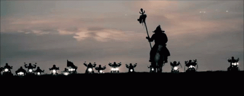 A Man Riding A Horse With A Flag In His Hand Is Leading A Group Of Motorcycle Riders GIF