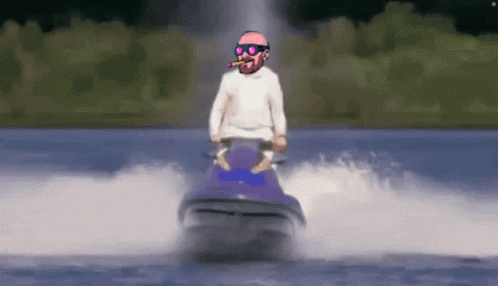 A Man Riding A Jet Ski In The Water With A Cigar In His Mouth GIF