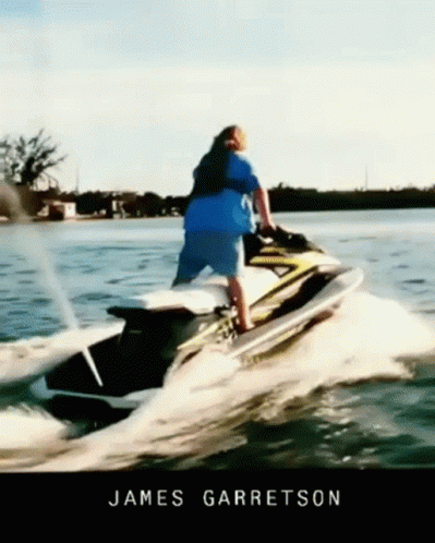 A Man Riding A Jet Ski In The Water With The Name James Garratson GIF