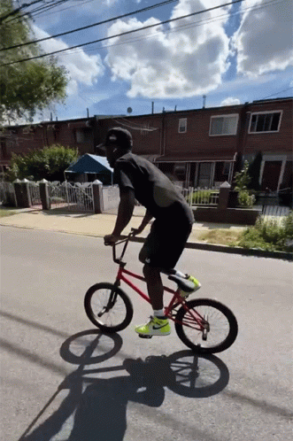 A Man Riding A Red Bmx Bike On A Street GIF