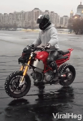 A Man Riding A Red Ducati Motorcycle In The Rain GIF