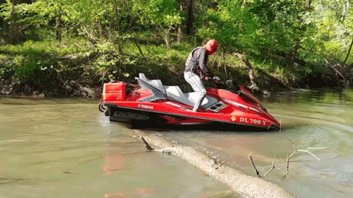A Man Riding A Red Yamaha Jet Ski In The Water GIF