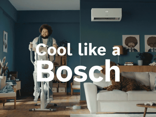 A Man Riding An Elliptical In A Living Room With The Words Cool Like A Bosch GIF