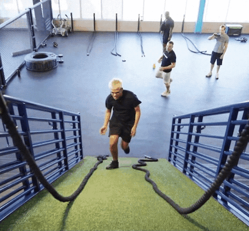 A Man Runs Up A Set Of Stairs With Ropes GIF