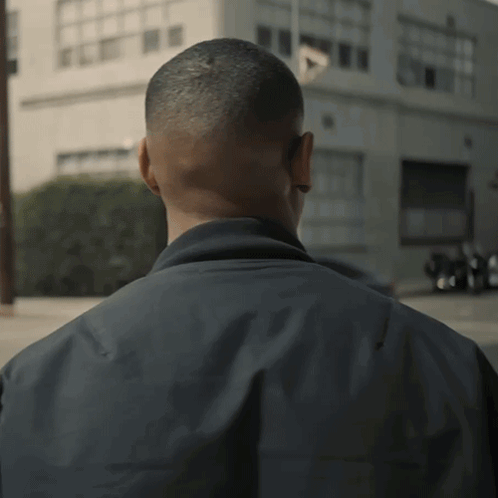 a man 's back is shown in a blurry photo with a building in the background
