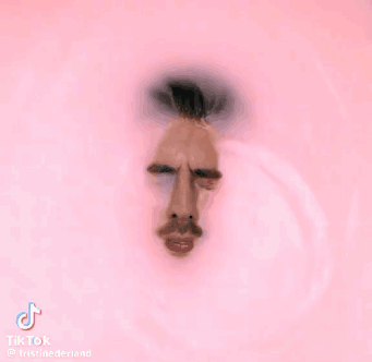 A Man 'S Face Is Visible Through A Hole In A Pink Wall GIF