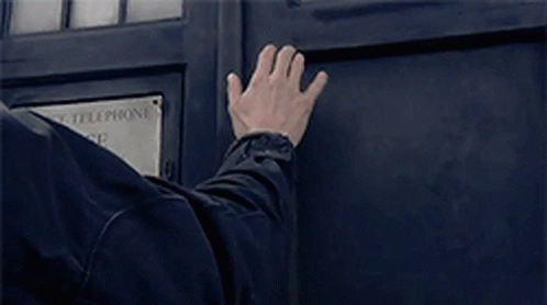 a man 's hand is reaching out to a police telephone box