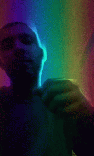 A Man 'S Hand Is Reaching Out Towards A Rainbow Light GIF