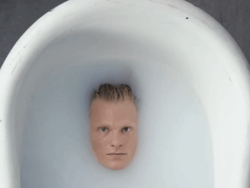 A Man 'S Head Is Sticking Out Of A White Bowl Of Water GIF