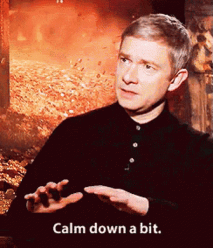 A Man Says Calm Down A Bit In Front Of A Fire Background GIF