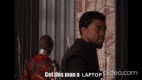 A Man Says Get This Man A Laptop In Front Of Another Man GIF