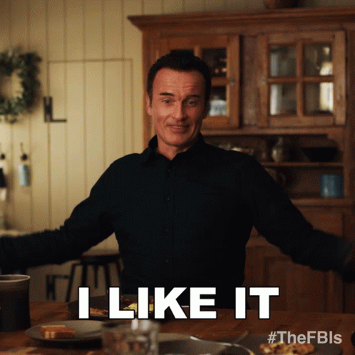 A Man Says I Like It While Standing In Front Of A Table GIF