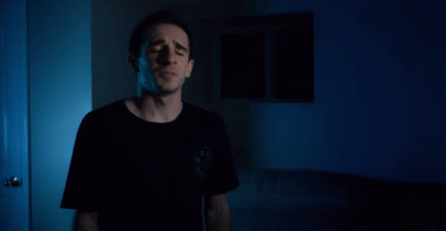 A Man Says I 'Ll Be Back In Front Of A Blue Background GIF