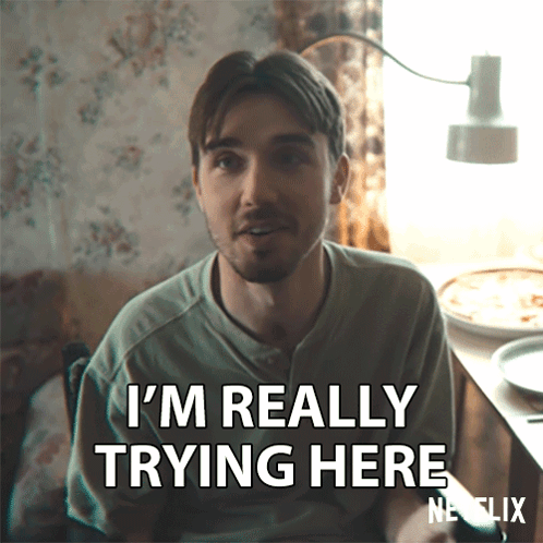 A Man Says I 'M Really Trying Here While Sitting At A Table GIF