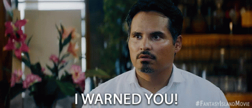 A Man Says " I Warned You " In Front Of Flowers GIF