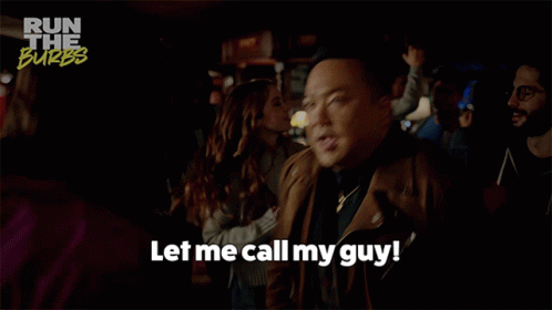 A Man Says " Let Me Call My Guy " In A Crowd GIF