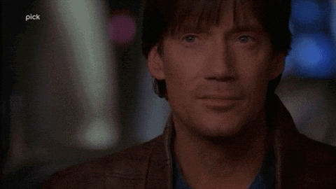 A Man Says " Let 'S Bring It " In Front Of A Dark Background GIF