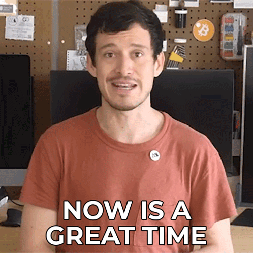 a man says now is a great time in front of a computer monitor