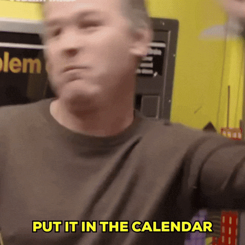 A Man Says Put It In The Calendar In Front Of A Yellow Wall GIF