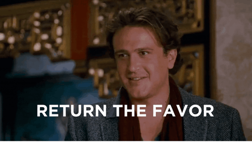 A Man Says Return The Favor In Front Of A Wall GIF