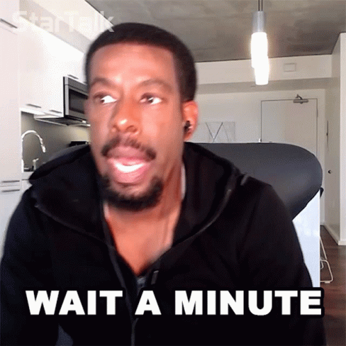 A Man Says Wait A Minute In Front Of A Kitchen GIF