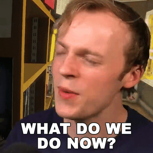 A Man Says What Do We Do Now In Front Of A Shelf GIF